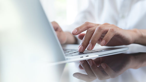 Closeup of person typing on a laptop