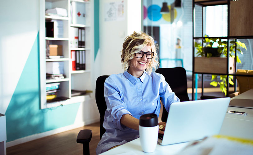 Creative team member smiling at desk.
