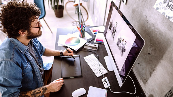 Employee using a drawing tablet with their computer.