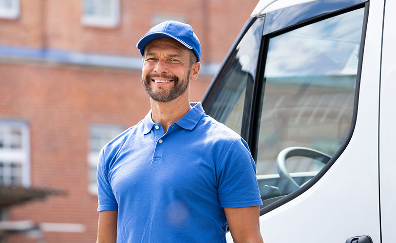 Local business owner in front of work vehicle