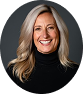 Studio headshot of a smiling blonde woman with shoulder-length hair wearing a black turtleneck inside a circular frame.